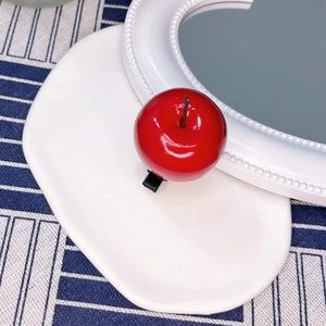Detailed view of red apple resin hair clip with glossy finish and metal duckbill clip