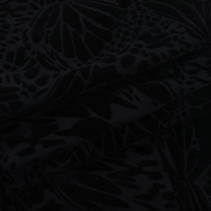 Macro detail of black flocked floral velvet fabric with elegant 3D texture and patterns