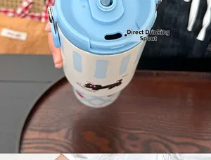 Detail view of large white insulated tumbler with blue stripes and cartoon dog pattern