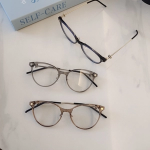 Detailed close-up of stylish round frames in black, grey, and tea colors on marble