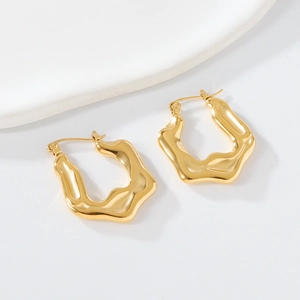 Detailed view of golden irregular geometric wave earrings with a liquid metal texture