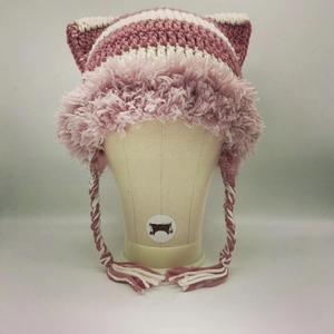 Detail of hand-knitted cat ear hat featuring pink star stripes and braided tassels