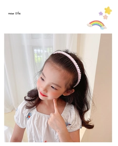 Detailed view of girls' pink satin ruffled headband with non-slip inner teeth