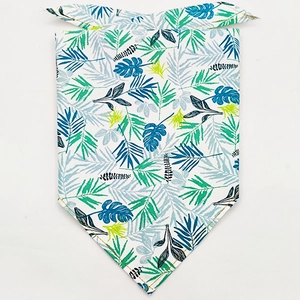 Flat lay detail of tropical leaf print pet bandana with sharp stitching on white background