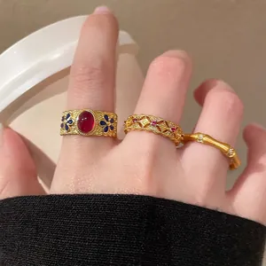 Close-up of vintage gold S925 silver rings with red rubies and blue enamel bamboo details