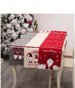 Close-up of embroidered Christmas table runner featuring festive gnomes and snowflakes
