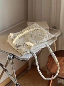 Gros plan du sac fourre-tout matelassé en velours à cœurs sur une chaise pliante