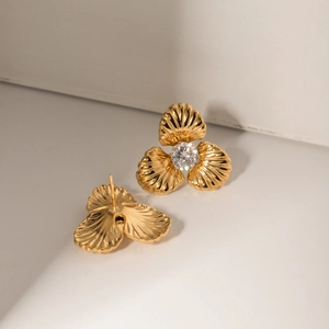 Close-up of 18k gold-plated floral stud earrings featuring a sparkling central zircon inlay