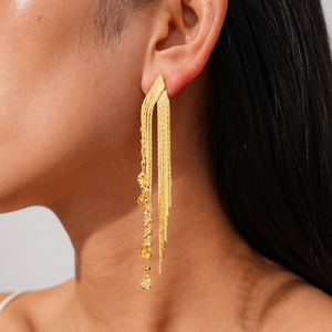 Detail of 18k gold plated long fringe tassel earrings with tiny heart pendant on model