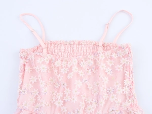 Détail de la broderie florale rose et du bustier smocké sur la robe en tulle