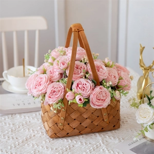 Pivoines et roses artificielles roses dans un panier en bois pour décoration