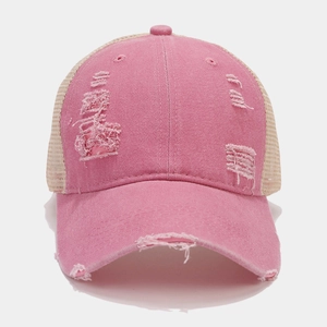 Detail of pink distressed denim baseball cap showing breathable beige mesh and ripped fabric