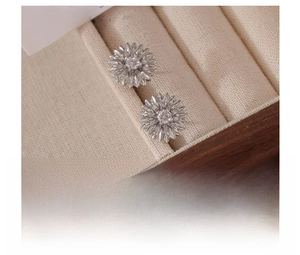 Macro shot of silver sunflower earrings featuring vacuum-plated titanium and zircon