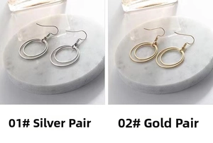 Close-up of minimalist double-hoop earrings in silver and gold on marble background