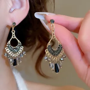 Retro ethnic style gold drop earrings with black crystal tassels and rhinestone details