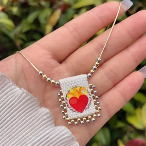 Detail of 18K gold-plated beaded chain with a rectangular Sacred Heart fabric pendant