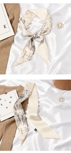 Detailed view of cream twilly scarf with grey sketching and capital H letter print