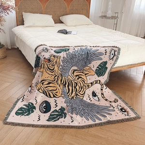 Artistic woven tiger throw blanket with tropical leaves and colorful tassels on wood floor