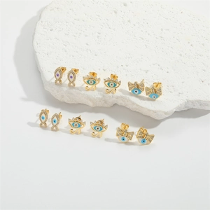 Golden Evil Eye Stud Earring Set with Zircon Inlays on a White Textured Stone