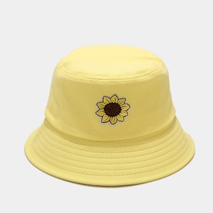 Dettaglio del cappello a secchiello giallo in cotone con ricamo girasole e cuciture fini