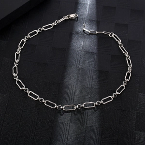 Minimalist silver stainless steel paperclip link chain necklace on black textured background