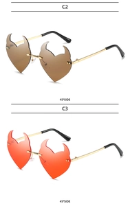 Detail view of heart-shaped devil horn sunglasses in brown and red with gold metal temples