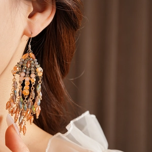 Detail of vintage bohemian chandelier earrings with amber beads on a female model