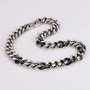 Detail of silver and black metal Cuban link necklace with polished interlocking design