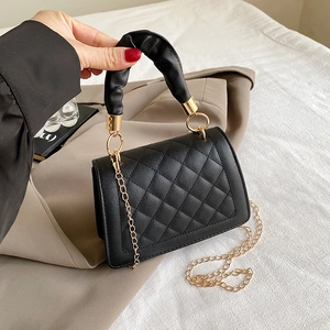 Primer plano del bolso acolchado negro con asa fruncida y correa de cadena dorada