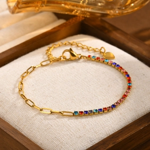 Macro shot of gold stainless steel bracelet with colored zircons and heart charm