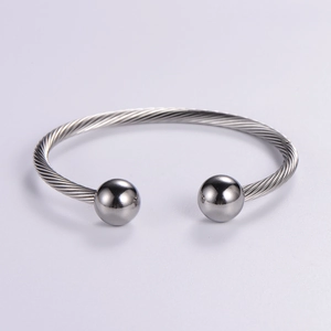 Minimalist silver braided twisted wire bangle with spherical end caps and open design