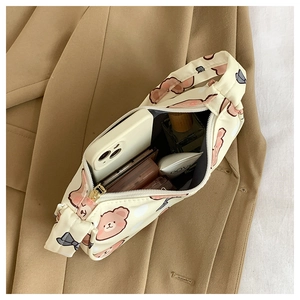 Top view of beige bear print cosmetic bag showing interior capacity with makeup items