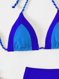 Detail of color-block bikini top with two-tone twisted halter straps in shades of blue