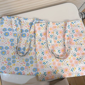 Detailed top view of large floral canvas tote bags with blue and pink patterns