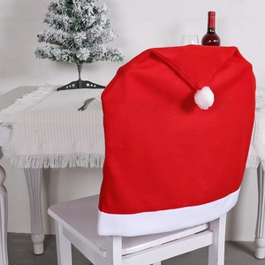 Red Christmas hat chair cover with white plush trim on a dining chair setting