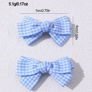 Detailed view of two blue checkered bow hair clips with specific size and weight measurements