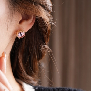Close-up of 18k gold plated earring with pink gemstone on ear