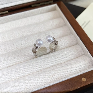 Macro view of silver spiral ring with double pearls in a luxury wooden jewelry box