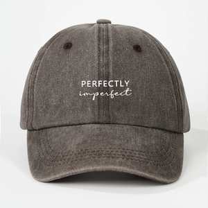 Close-up of dark grey washed cotton baseball cap featuring PERFECTLY imperfect print
