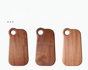 Detailed view of the natural wood grain and hanging holes on three solid ebony cutting boards