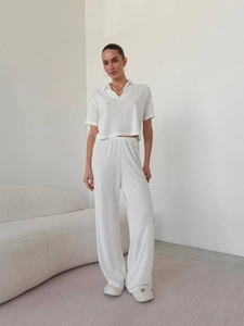 Women's white knitted two-piece set featuring a short sleeve polo top and wide leg pants