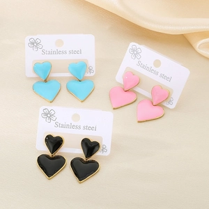 Gros plan sur les boucles d'oreilles cœur plaquées or 18k en bleu, rose et noir acier