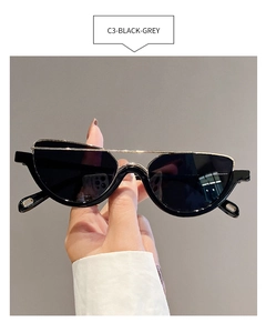 Detail of fashion half-frame sunglasses with gold bridge and black grey lenses