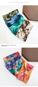 Detailed view of colorful tie-dye elastic yoga headbands on a wooden display tray