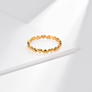Minimalist gold heart-shaped stackable stainless steel ring on white geometric background