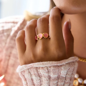 Bague romantique en or avec cœurs en œil de chat rose portée par un mannequin