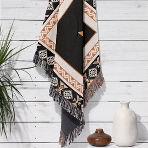 Detail of bohemian cotton blanket with geometric patterns and fringe edges for home decor