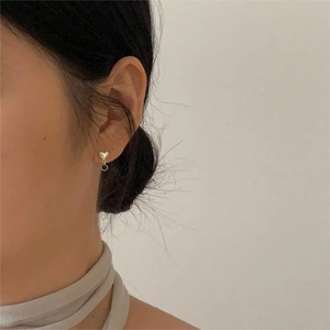 Detail of 925 sterling silver heart stud earrings with black stone and chain drop