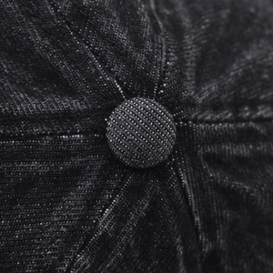 Macro shot of the stitched crown and fabric button on this black washed denim baseball cap
