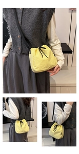 Detail view of the yellow nylon drawstring bucket bag with adjustable shoulder straps